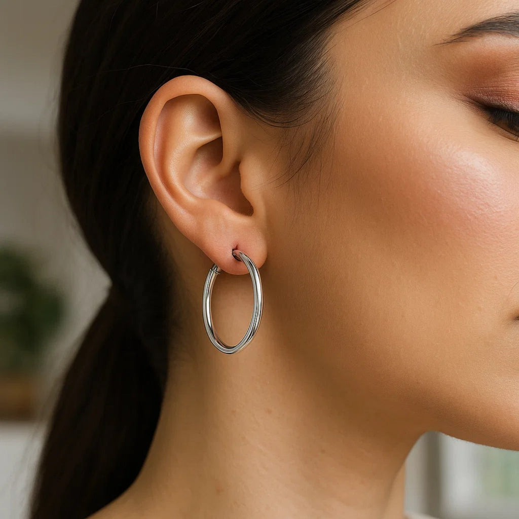 Sterling silver polished hoop earrings with rhodium plating, showcasing a sleek modern design for elegant wear.