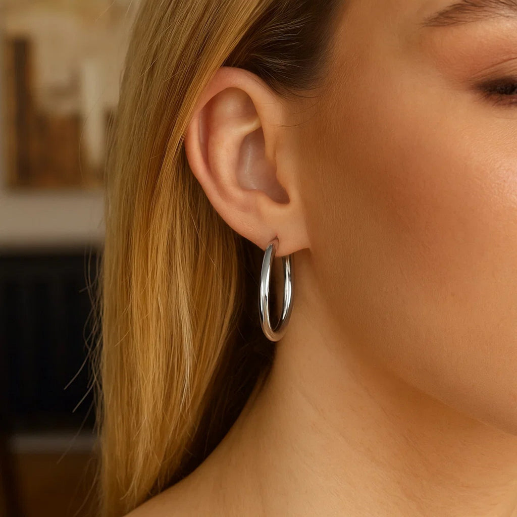 Sterling silver polished hoop earrings with rhodium plating, showcasing a sleek modern design and exquisite craftsmanship.
