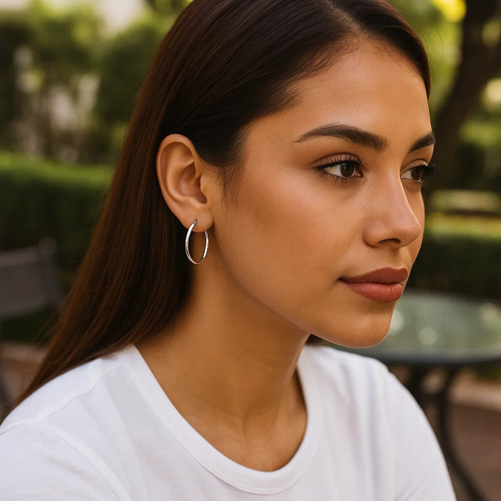 Sterling silver polished hoop earrings with rhodium plating, showcasing a sleek modern design and elegant shine.