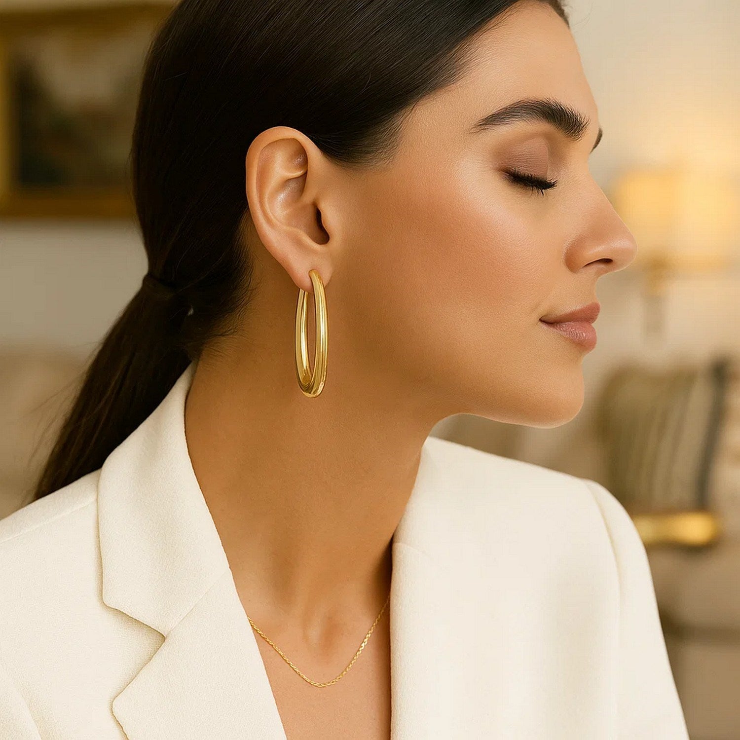 14k yellow gold elongated oval hoop earrings with a contemporary design, perfect for elegant occasions.