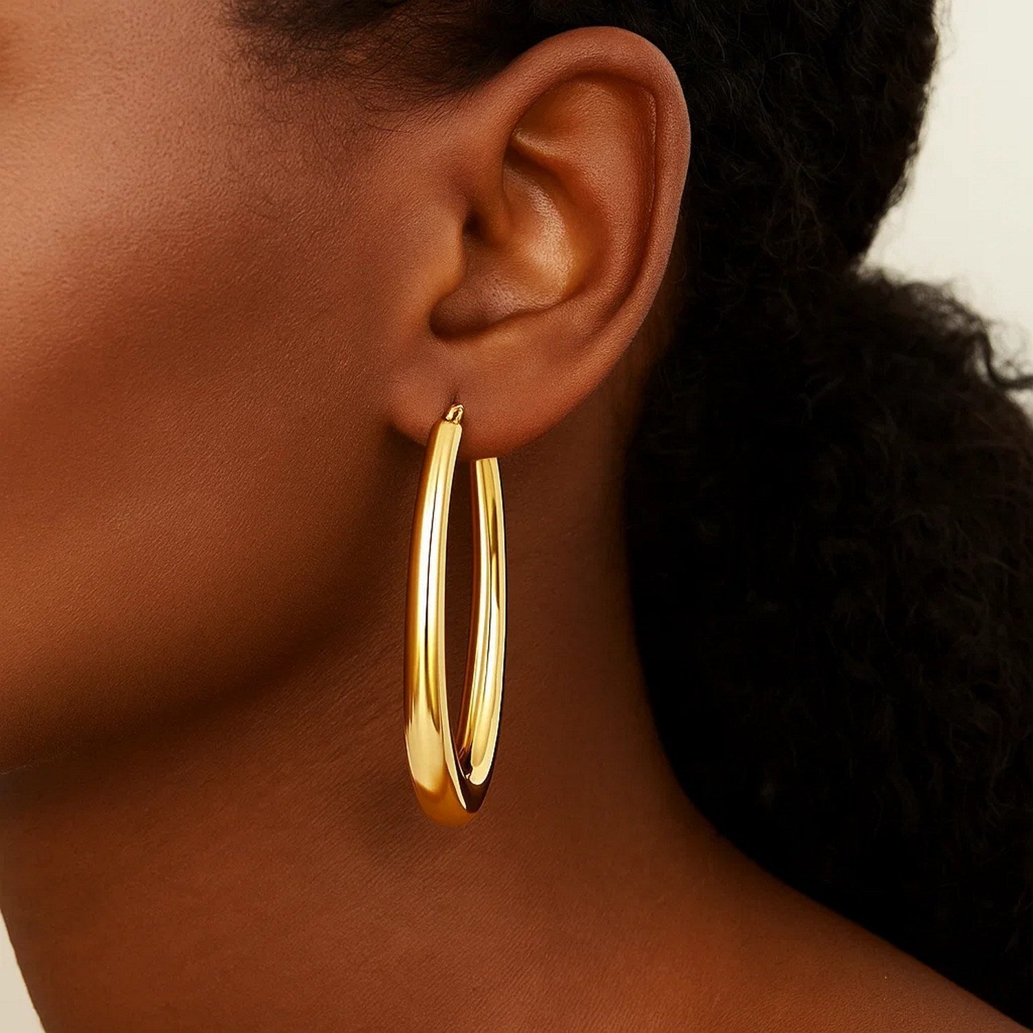 14k yellow gold elongated oval hoop earrings with a contemporary design, perfect for elegant occasions.