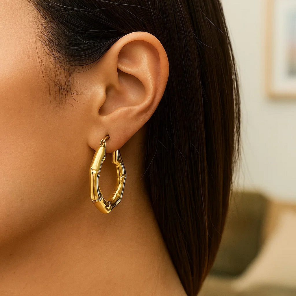 14k yellow gold polished bamboo hoop earrings with a modern design, showcasing elegance and luxury.