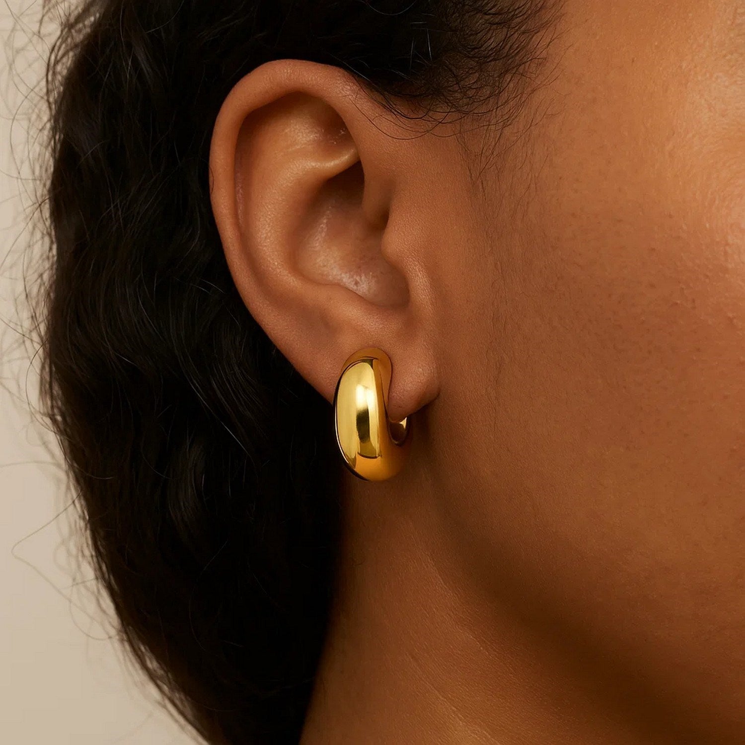14k yellow gold polished small omega hoop earrings with a contemporary design, perfect for elegant everyday wear.