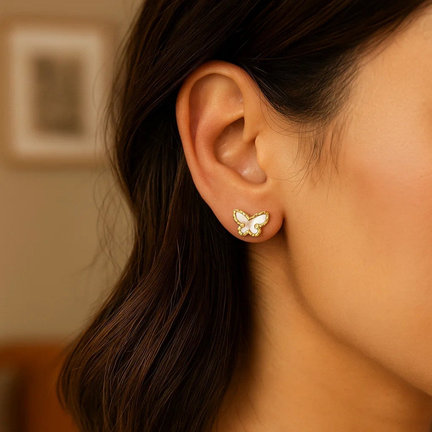 Elegant 14k yellow gold stud earrings featuring exquisite mother of pearl in a delicate butterfly design.