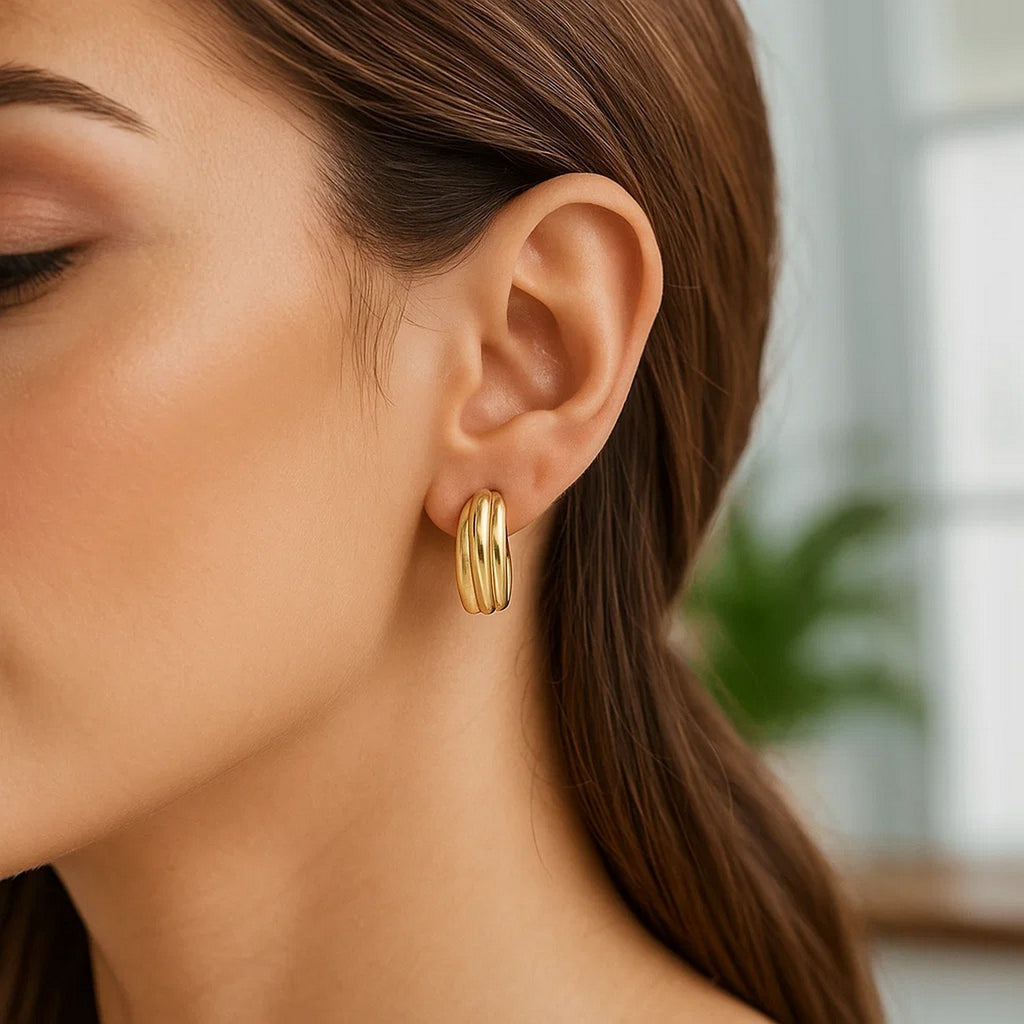 Elegant 14k yellow gold ribbed hoop earrings showcasing a refined design for a luxurious statement.