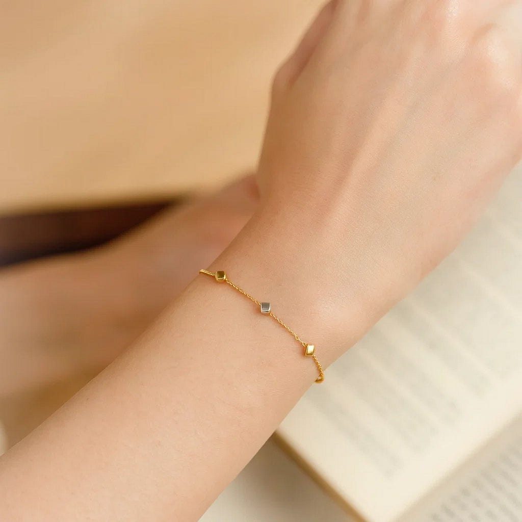 14k two-tone gold bracelet featuring polished cubes on a modern chain, exuding elegance and contemporary style.