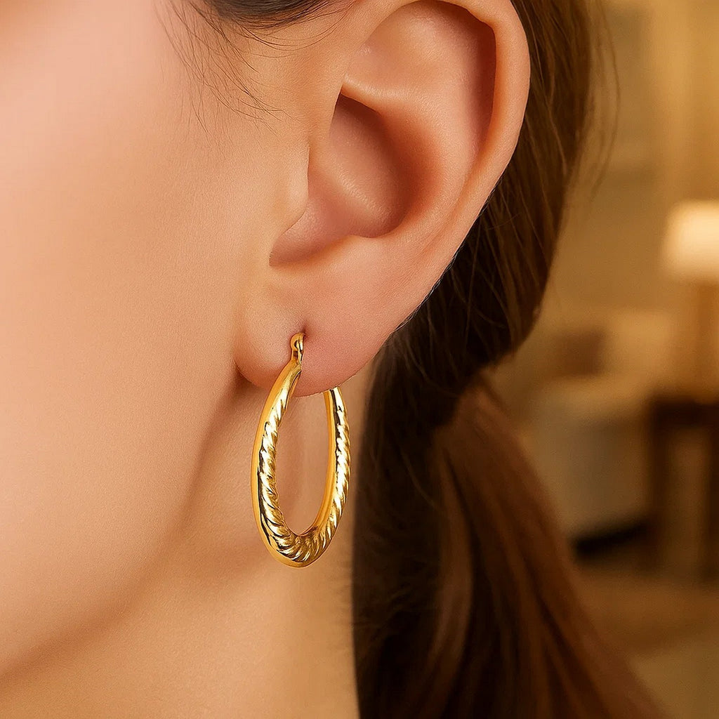 Elegant 14k yellow gold textured hoop earrings showcasing refined craftsmanship and timeless design.